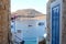 Amazing view among stone houses from Rhodes island in Greece, blue door and remarkable yacht