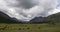 Amazing view of a valley and grassland with animals around the place on a cloudy day