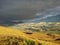 Amazing view of a valley, a thunder storm Comes up, one half cloudy and dark, other half sunny and friendly