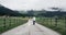 Amazing vintage road with fantastic view of mountains and with attractive couple walking down. slow motion