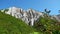 Amazing white mountains with green grass. Clip. Beautiful patterns on rocky white mountain with bright greenery on sunny