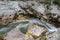 Amazing wild water in mala korita Soce valley, small pure clear turquoise flowing stream through stone gorge