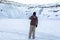 Amazing winter landscape in the crater of a volcano on the frozen lake Kerid. The guy walks along the frozen lake inside the