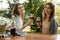 Amazing young two women sitting outdoors in park drinking wine