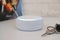 Amazon echo dot , Alexa voice controlled speaker with activated voice recognition, on brick and white background