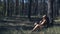 Amazon woman in leather clothes is resting under a tree in the forest