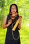 Amazonian exotic woman, facial paint and black dress, arrow case with small wooden bottle hanging around neck, posing