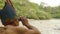 Amazonian Indigenous Man Watching Through A Binocular A Person In A Kayak