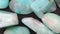 Amazonite jewel heap texture. Pile mineral pebbles background. Moving right seamless loop backdrop