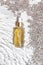 Amber bottle of lavender essential oil. Flat lay concept. Light background with water waves.