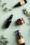 Amber glass cosmetic bottles and eucalyptus leavers on green background top view. SPA natural organic cosmetics set. Skincare