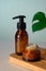 Amber glass cosmetics bottle on wooden board and tropical plant leaf