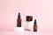 Amber glass dropper cosmetic bottles, white podium on pastel pink background. Scene with geometric shapes. Showcase for the