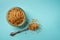 Amber sugar in a glass sugar bowl and tea spoon over blue background. Large crystals of brown unrefined cane sugar for tea and