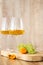 Amber or white wine with fruit. Poured glass with wine surrounded by grapes, peaches and pears