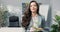 Ambitious beautiful smiling brunette in shirt stands in front of desk in company office in hands holds box with packed