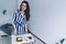 Ambitious smart woman in pleasant outfit resting laptop against worktop