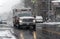 Ambulance drives through street in snow storm