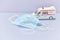 Ambulance model with medical mask on white background