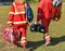 Ambulance staff with medical equipment on a sport track