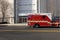 An ambulance on a street in front of a building with glass doors