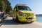 Ambulance van on a busy beach road full of people in hot summer