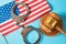America flag and judge`s hammer next to handcuffs