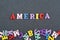 America word on black board background composed from colorful abc alphabet block wooden letters, copy space for ad text