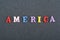 America word on black board background composed from colorful abc alphabet block wooden letters, copy space for ad text