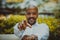 American african confident businessman in white shirt pointing hand to camera and smiling outside corporate office.Peace