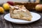 American apple Tsvetaevsky jellied open pie piece on a plate, close-up, on a dark wooden background. Flat lay