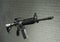 American army rifle M4A1 against a brick wall