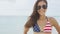 American bikini woman portrait smiling on beach with USA flag fashion swimwear
