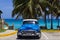 American blue Buick Eight classic car parked under palms on the beach in Varadero Cuba -Serie Cuba Reportage