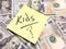 American cash money and yellow post it note with text Kids with question mark