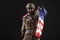 American commando in military equipment holds USA flag at night, modern ranger screams in the dark, elite troops