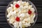 American dessert salad consisting of rice, marshmallows and pineapple dressed with whipped cream close-up in a plate. horizontal