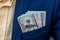 American dollar banknotes in businessman jacket`s pocket.