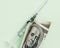 American dollar with Benjamin Franklin and empty syringe on pink background, concept of drugs, Coronavirus vaccine, flat lay