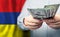 American dollars cash money in hand on Armenian flag background. Politics, business and social problems concept