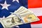 American dollars lie against the backdrop of the US flag, the independence and sustainability of the American economy