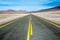 American empty desert asphalt road from low angle with mountains and clouds on background. South american highway in Atacama deser
