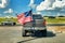 American flag on the back of truck on roadway.