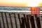 American flag on beach fence with sunset glow