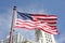 American Flag with buildings behind it