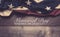 An American flag or bunting on a wooden background with memorial day greeting