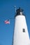 American Flag Flies Near White Lighthouse Tower