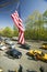 American Flag flies over Central Park in spring with yellow taxies in front of Helmsely Park Lane, Manhattan, New York City, NY