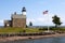 American Flag Flying Near Stone Lighthouse in Connecticut