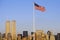 American Flag flying over skyline of New York City from New York Harbor, NY